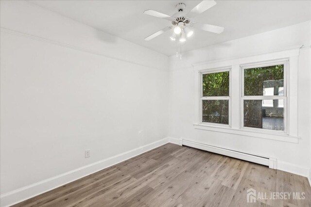 empty room featuring ceiling fan, light hardwood / wood-style flooring, and a baseboard radiator