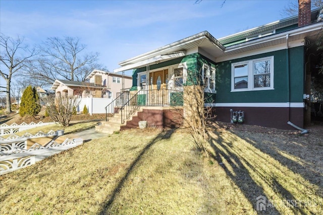 view of front of house featuring covered porch and a front yard