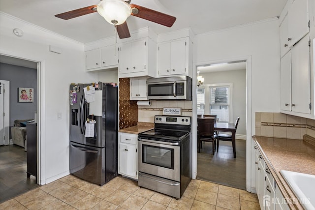 263 Bordentown Ave, South Amboy, NJ 08879 - kitchen with appliances with stainless steel finishes, a ceiling fan, tasteful backsplash, white cabinetry, and crown molding
