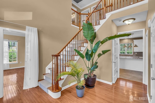 4 Angelina Ct, Monroe, NJ 08831 - staircase featuring wood-type flooring, baseboards, a high ceiling, and crown molding