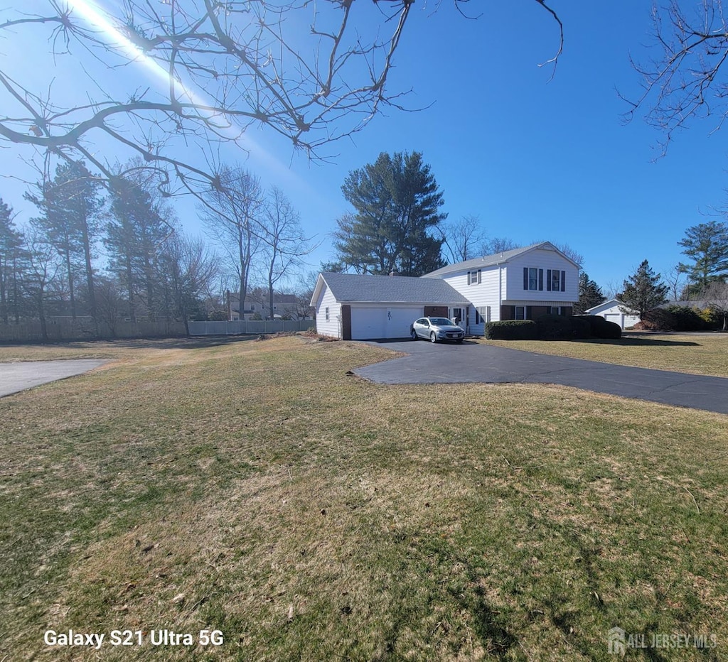 view of front of home featuring a front lawn, a garage, and driveway