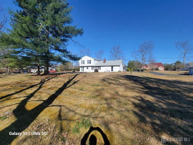 view of front facade with a chimney and a front lawn