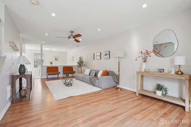 living area featuring ceiling fan, a textured ceiling, wood finished floors, and recessed lighting