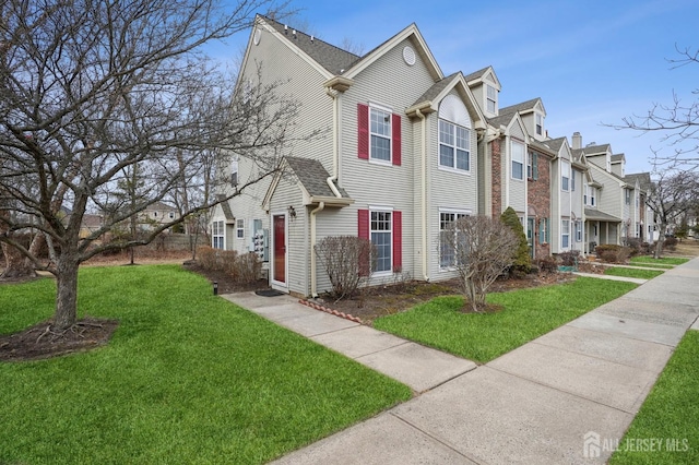 view of side of home featuring a residential view and a lawn