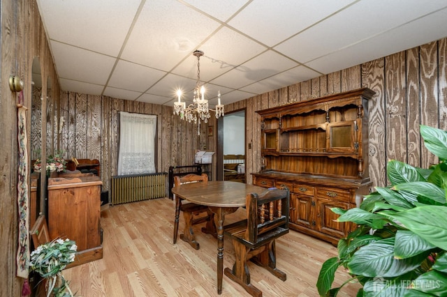 45 Lake Ave, Helmetta, NJ 08828 - dining area featuring a paneled ceiling, radiator heating unit, light wood-style floors, wooden walls, and a chandelier