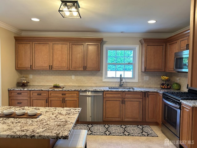 18 Timber Rd, East Brunswick, NJ 08816 - kitchen featuring appliances with stainless steel finishes, a sink, brown cabinets, decorative backsplash, and light stone countertops