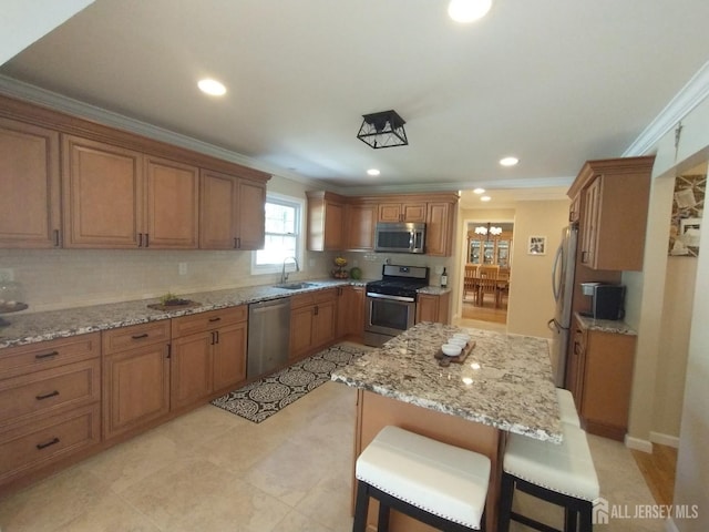 18 Timber Rd, East Brunswick, NJ 08816 - kitchen with appliances with stainless steel finishes, a sink, brown cabinetry, crown molding, and light stone countertops
