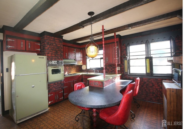 kitchen with white appliances, backsplash, range hood, pendant lighting, and beam ceiling