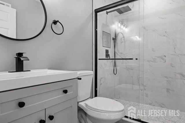 bathroom with toilet, a shower with door, and vanity