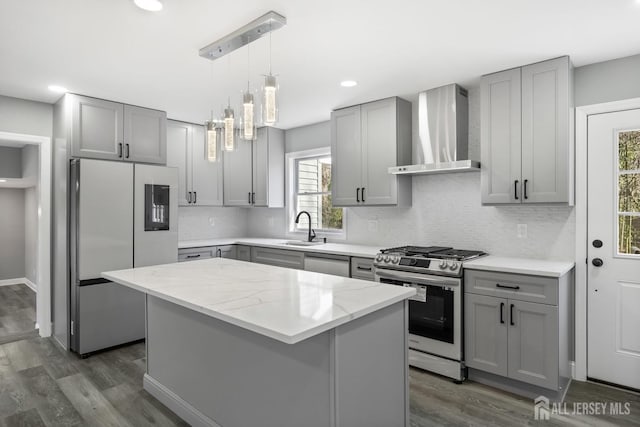 kitchen with stainless steel appliances, dark hardwood / wood-style floors, light stone countertops, a kitchen island, and wall chimney range hood