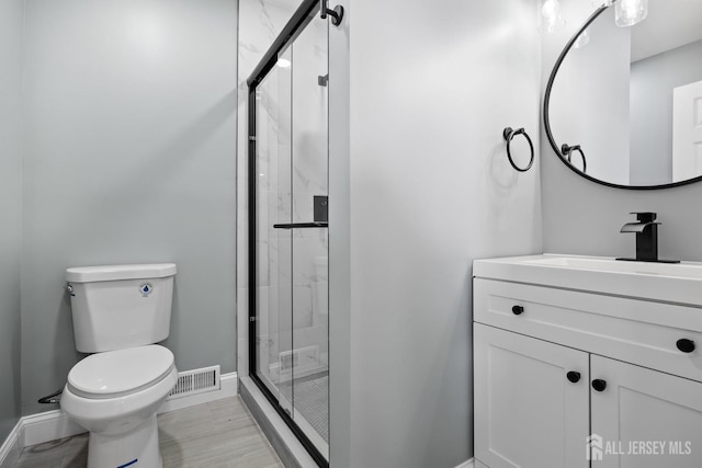 bathroom featuring toilet, vanity, and walk in shower