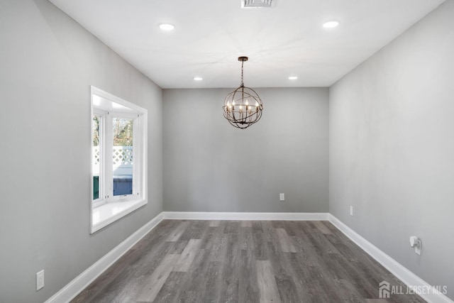 unfurnished dining area with dark wood-type flooring and a chandelier