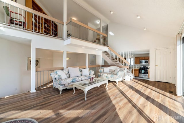 living room with hardwood / wood-style flooring and high vaulted ceiling