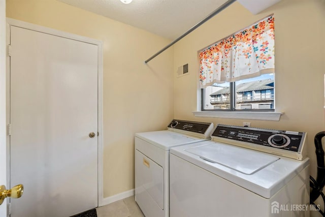 laundry room with light tile patterned floors and washing machine and clothes dryer