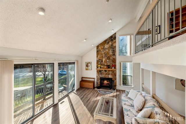 living room featuring a fireplace, hardwood / wood-style floors, a textured ceiling, and lofted ceiling