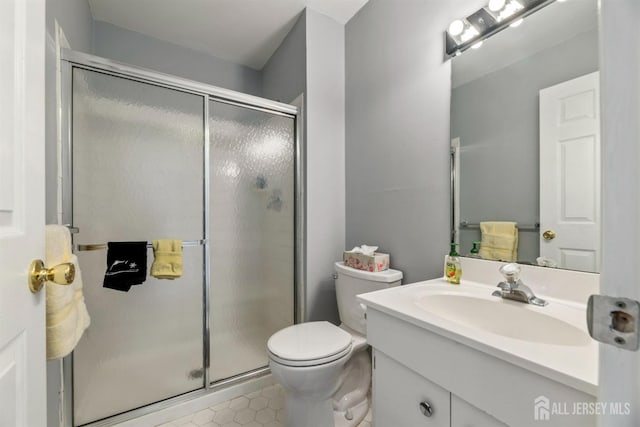 bathroom with tile patterned floors, vanity, toilet, and a shower with shower door