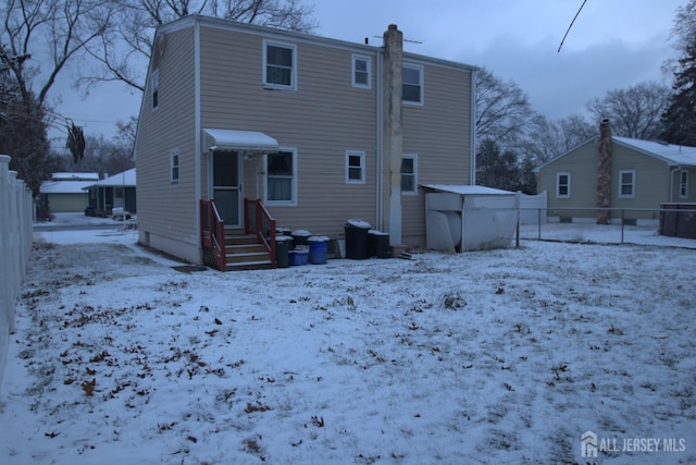 view of snow covered rear of property