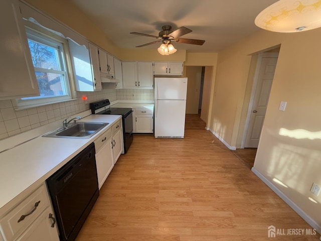 kitchen with sink, white cabinets, black appliances, and tasteful backsplash