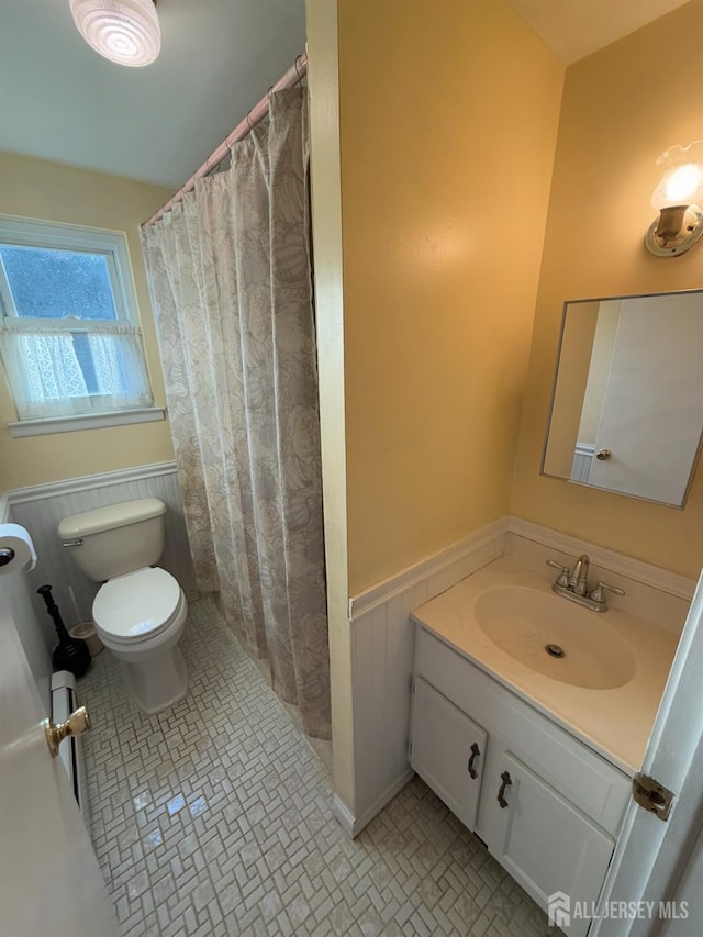 bathroom with toilet, tile patterned flooring, walk in shower, and vanity