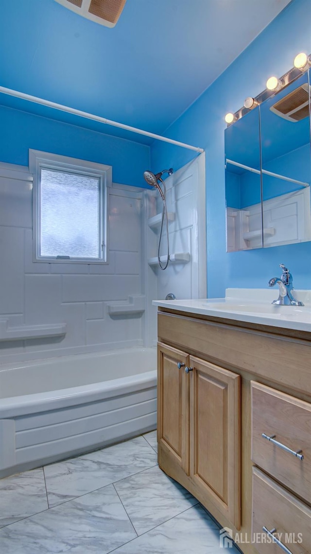 full bathroom with marble finish floor, shower / bathing tub combination, and vanity