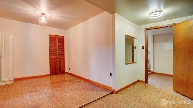 unfurnished room with light floors and baseboards