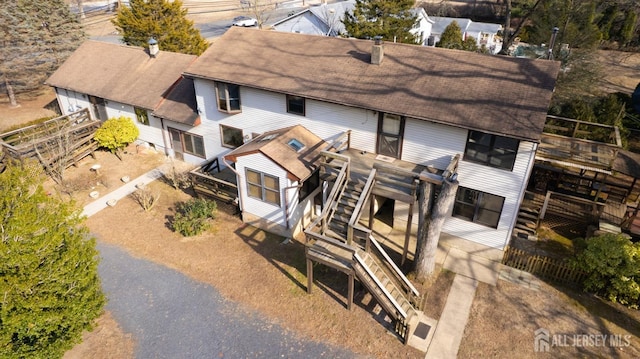 exterior space featuring driveway, stairway, and roof with shingles