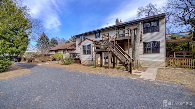 view of front of home featuring stairs, a chimney, and a wooden deck