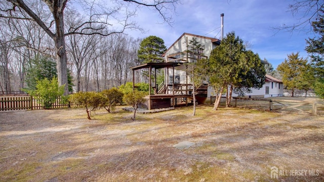 view of yard featuring fence and a wooden deck