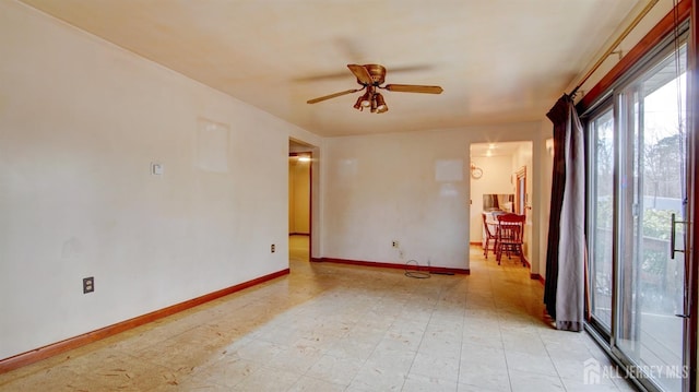 empty room with light floors, a ceiling fan, and baseboards