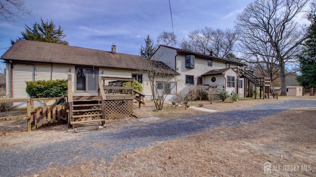 view of front of property featuring stairway, fence, and a wooden deck