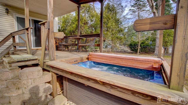 wooden deck featuring fence and a hot tub