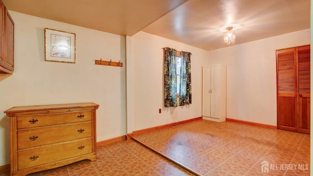 unfurnished bedroom featuring light floors and baseboards