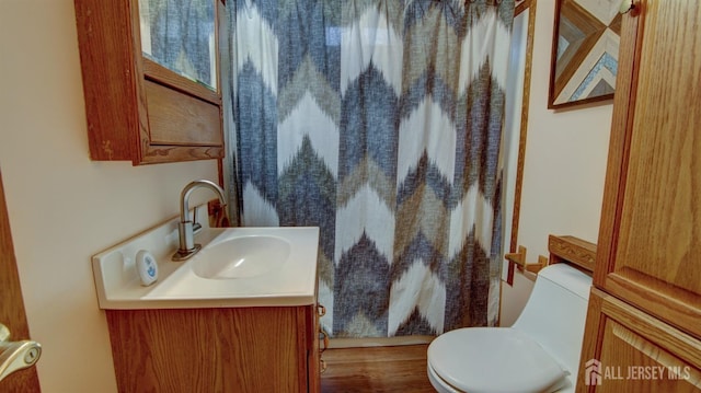 full bath featuring toilet, curtained shower, and vanity