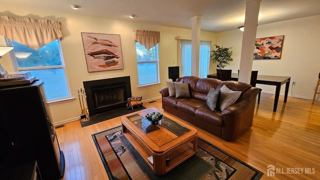 living room featuring light hardwood / wood-style flooring and decorative columns