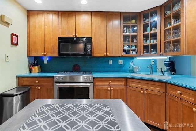 22 S Drive E, Brunswick, NJ 08816 - kitchen with black microwave, stainless steel stove, a sink, brown cabinets, and tasteful backsplash
