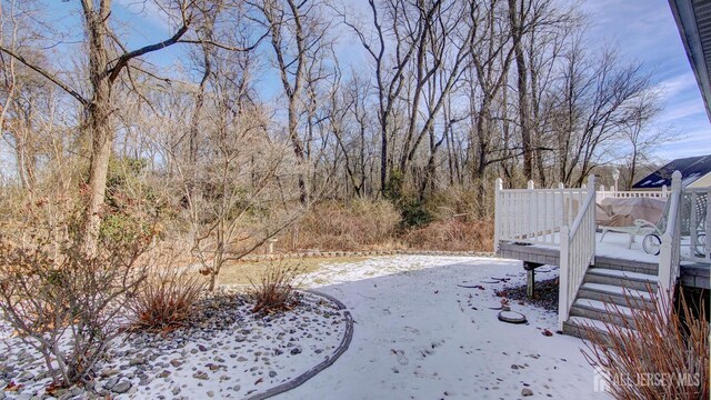 snowy yard featuring a deck