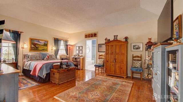 bedroom with a textured ceiling and dark hardwood / wood-style floors