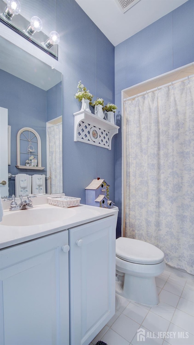 bathroom featuring vanity, tile patterned floors, and toilet