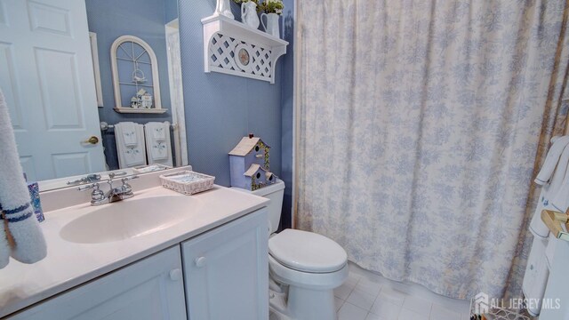 bathroom featuring vanity, tile patterned flooring, and toilet