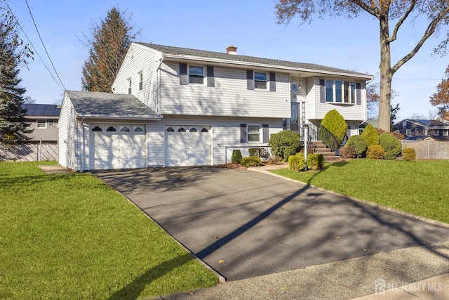 split foyer home with a garage and a front yard