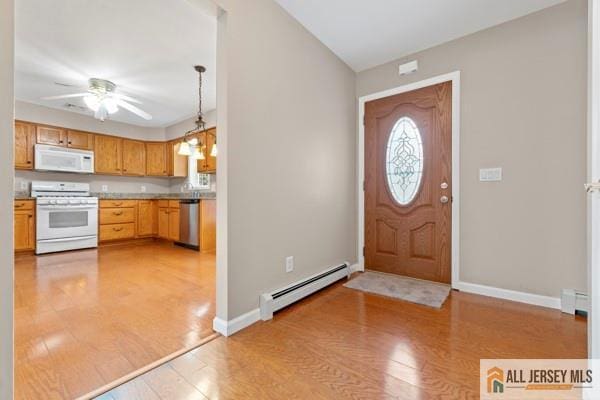 entrance foyer featuring a baseboard radiator, ceiling fan, and light hardwood / wood-style floors