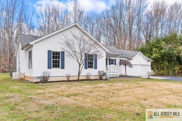 ranch-style home featuring a garage, central AC, and a front yard