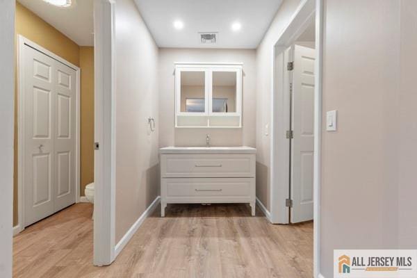 hall featuring sink and light hardwood / wood-style flooring