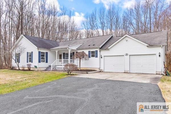 ranch-style home with a garage, a porch, and a front lawn