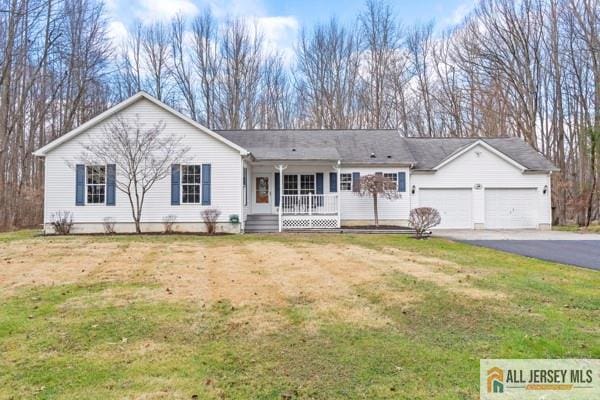 ranch-style house with a garage, covered porch, and a front lawn