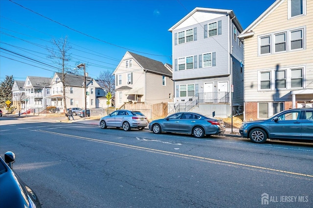 exterior space with street lighting, a residential view, and curbs