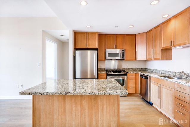 20 Livingston Ave Unit 504, New Brunswick, NJ 08901 - kitchen featuring stainless steel appliances, light wood-style floors, a kitchen island, recessed lighting, and light stone countertops