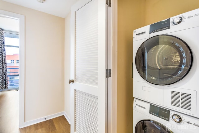 20 Livingston Ave Unit 504, New Brunswick, NJ 08901 - laundry room featuring stacked washer / drying machine, wood finished floors, and healthy amount of natural light