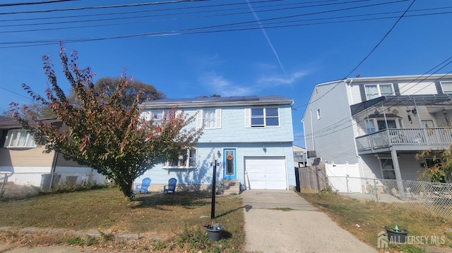 view of front of property with a garage, a front yard, and solar panels