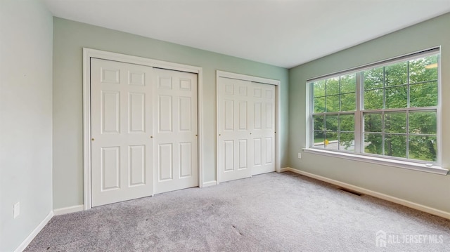612 Magnolia Rd, North Brunswick, NJ 08902 - unfurnished bedroom with two closets, carpet flooring, and baseboards